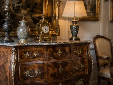 Commode ancienne en marqueterie avec plateau de marbre, pendule dorée et vases, dans un intérieur de collectionneur