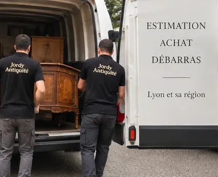Deux hommes en tee-shirt Jordy Dellinger chargent une commode ancienne dans une camionnette blanche