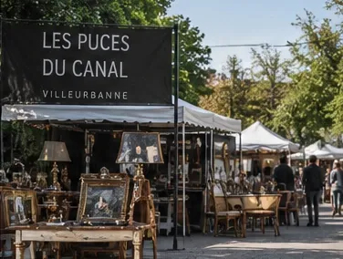 Stand de brocante sous tente au marché aux puces Les Puces du Canal, avec cadres, lampes et chaises anciennes